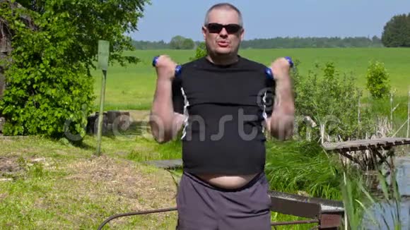 超重的人用哑铃做二头肌的运动视频的预览图