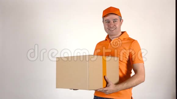 穿橙色制服的送货员送了一个大盒子浅灰色背景4K摄影棚拍摄视频的预览图