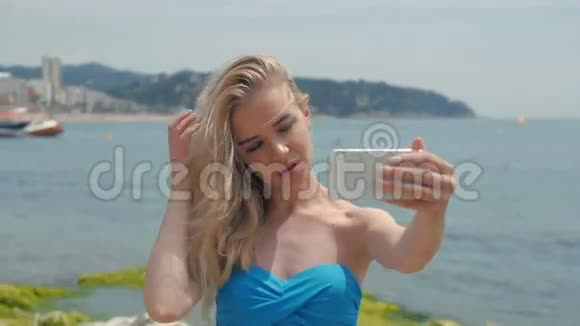 暑假海滩度假女孩用智能手机拍摄有趣的手机自拍照片可爱的戴蓝色太阳镜的亚洲女人视频的预览图