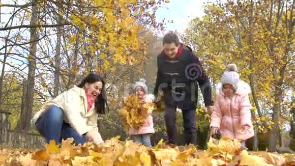 秋天公园的幸福家庭妈妈爸爸和两个小女孩视频的预览图