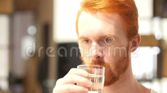 漂亮的年轻人在室内喝一杯水来保持健康视频的预览图