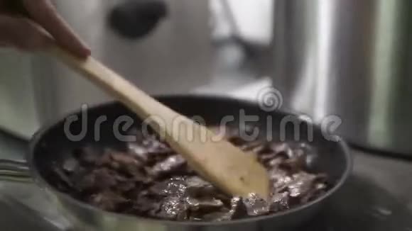 把肉放在煎锅里煮在空气中混合铲子和土豆视频的预览图