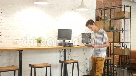 男子步行放松和使用平板电脑在办公室工作视频的预览图