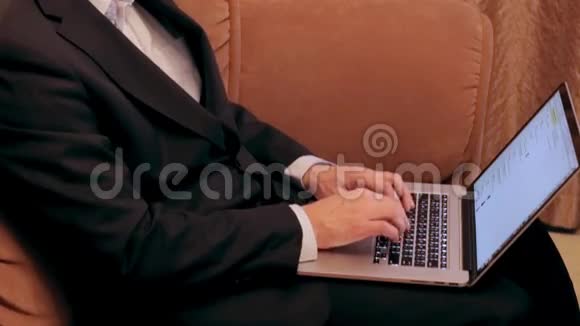 男人一边打字一边坐在沙发上视频的预览图