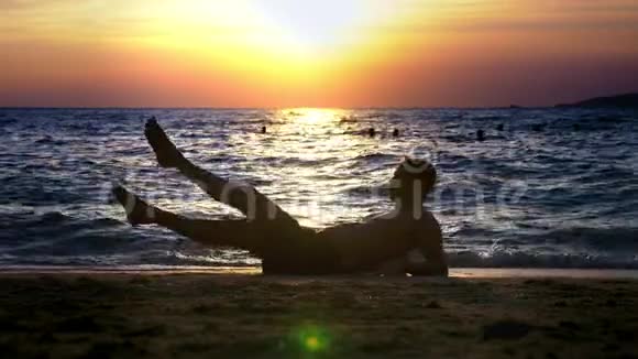 一个穿短裤的帅哥在海边做健身运动背景是美丽的日落视频的预览图