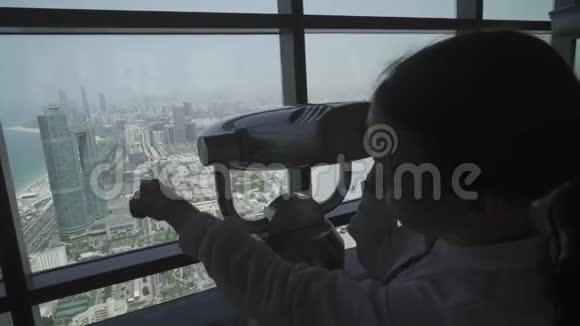 少女透过阿布扎比望远镜从观察甲板上看股票录像视频的预览图