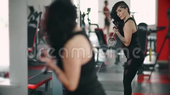 强壮的黑发女人在健身房举重视频的预览图