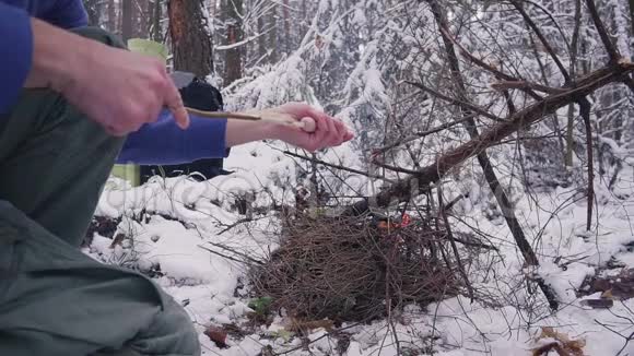 冬天森林里篝火上烤香肠视频的预览图
