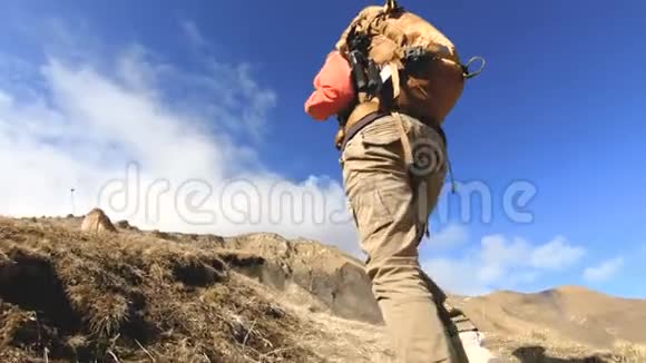 快乐的旅行女孩摄影师带着相机和背包在白雪皑皑的背景下上山视频的预览图