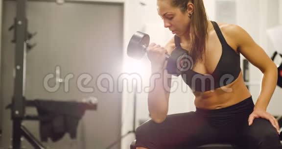 健康训练有素的女性在健身馆举重视频的预览图