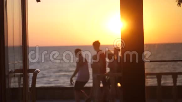幸福的一家人在日落时漫步在海滩上海景模糊的背景1920x1080视频的预览图