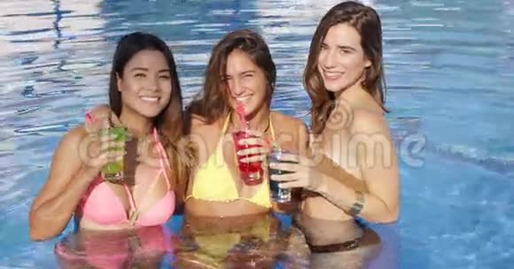 三位美女在泳池边喝着五颜六色的饮料视频的预览图