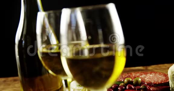 两杯葡萄酒和一个带有浆果水果和橄榄的托盘视频的预览图