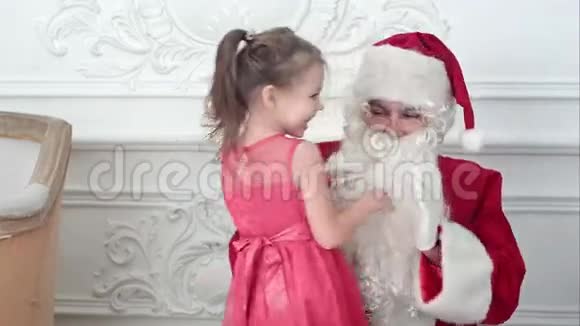 圣诞老人拍手而漂亮的小女孩围着他跳舞视频的预览图