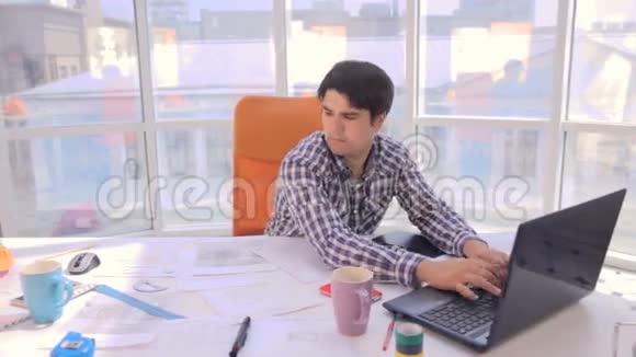 年轻忙碌的商人在一个轻盈现代化的办公室里工作图纸蓝图视频的预览图