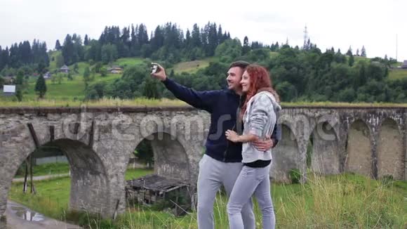 快乐的一对情侣在老高架桥前自拍视频的预览图