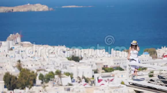 美丽的年轻女子在豪华酒店看书在希腊的Mykonos有着令人惊叹的景色视频的预览图