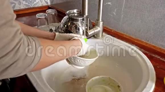 女人带着手套在厨房洗碗视频的预览图