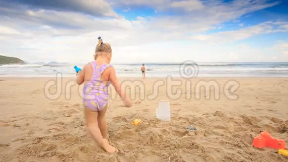 小女孩男孩跑在湿沙滩玩红球视频的预览图