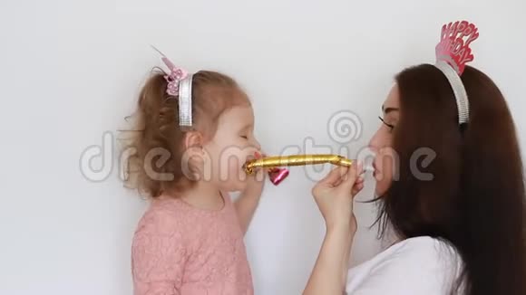 生日快乐派对母亲和女儿吹角微笑玩得开心笑庆祝一个女人和她的孩子视频的预览图