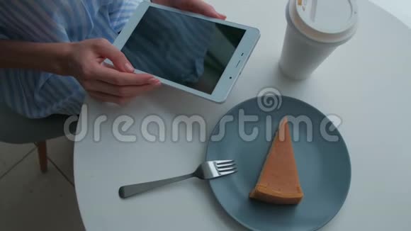 女性坐在自助餐厅使用数码平板电脑视频的预览图