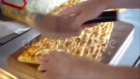 男人在厨房里用芝麻切馅饼视频的预览图