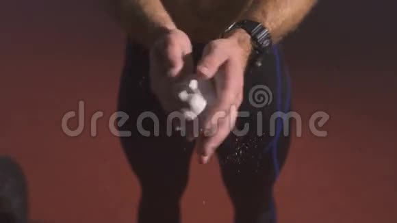 强壮的男人把镁粉涂在手掌上准备做运动视频的预览图