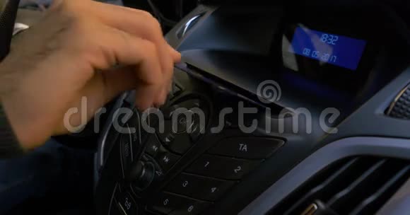 男人手把磁盘放进汽车播放器里汽车中的光盘播放器按钮控制手把磁盘放入视频的预览图