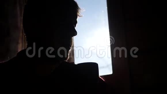 男人独自坐在窗前蓝天喝着一杯热茶慢动作高清1920x1080视频的预览图