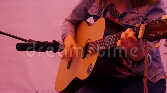 年轻的时髦女人弹吉他特写镜头女孩在街上玩视频的预览图