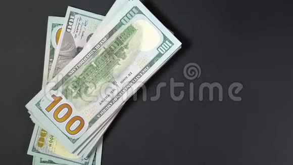 一堆100美元的钞票在黑色背景上放置您的徽标或文本视频的预览图