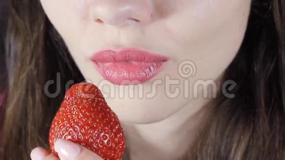 慢悠悠地吃草莓的女人性感的红唇红指甲和唇膏视频的预览图