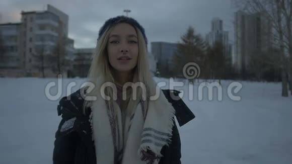 美丽的女孩站在雪地里视频的预览图