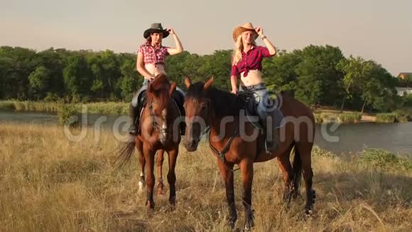 两个女孩在日落时在一片田野里骑马视频的预览图