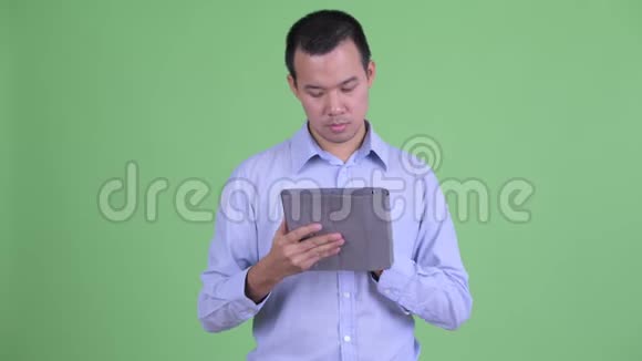 快乐的亚洲商人用数码平板电脑思考视频的预览图