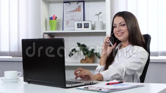 商务女性坐在办公室手提电脑前打电话视频的预览图