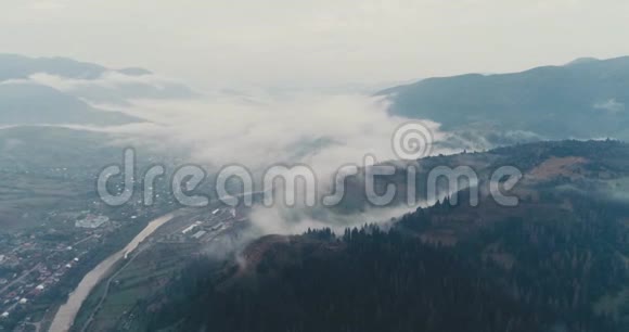 鸟瞰薄雾般的森林在横贯喀尔巴阡山脉的城市里飞翔视频的预览图