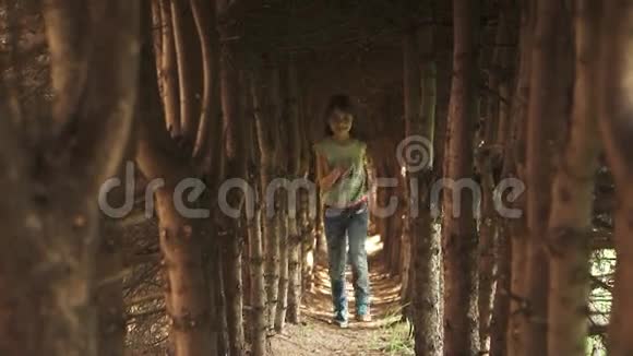 小女孩穿过树洞神秘而神奇的森林里的孩子慢动作视频的预览图