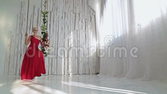 漂亮年轻性感的女人穿着红色的裙子摆着鲜花视频的预览图
