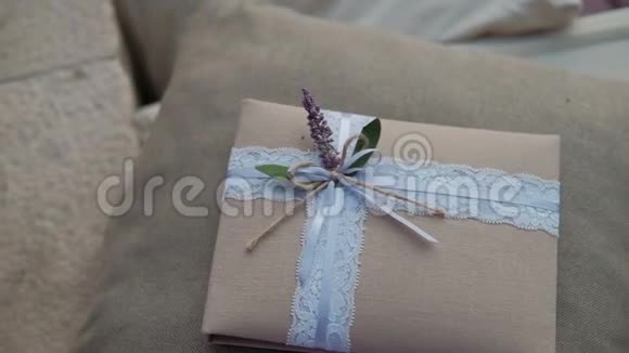 礼品在纸巾包装与精致的丝带和花躺在枕头在房间视频的预览图