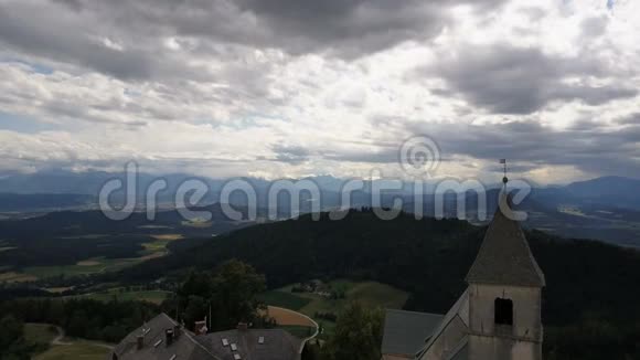 在山上的古老教堂上空飞行奥地利卡林西亚的Magdalensberg的鸟瞰图美丽的山脉视频的预览图