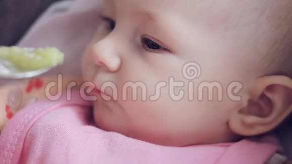 妈妈用勺子喂她可爱的新生婴儿西葫芦特写视频的预览图