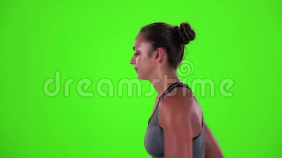 运动的女人在慢跑侧视绿色屏幕慢动作视频的预览图