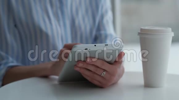女性坐在自助餐厅使用数码平板电脑视频的预览图