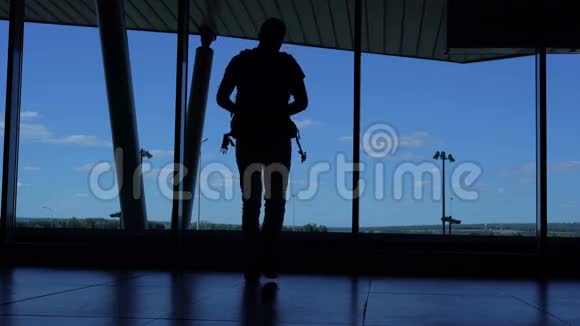 带背包的年轻人站在机场休息室享受你的智能手机视频的预览图
