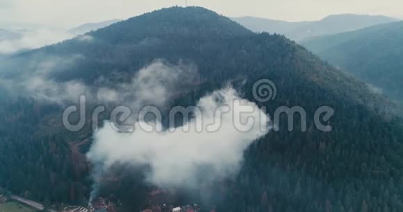 鸟瞰雾蒙蒙的森林在横贯喀尔巴阡山脉的城市Mizhgirja穿云飞行视频的预览图