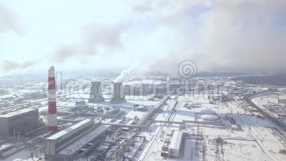 工业工厂和吸烟烟囱在冬季城市无人机视野发电厂工业管道排放的烟雾视频的预览图