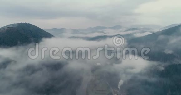 鸟瞰薄雾般的森林在横贯喀尔巴阡山脉的城市里飞翔视频的预览图