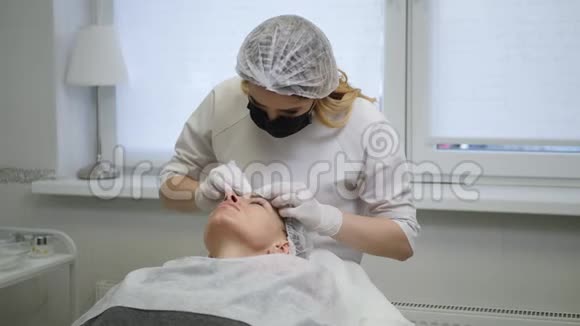 医生的美容师戴着黑色面具为一个年轻女人清洗脸部视频的预览图