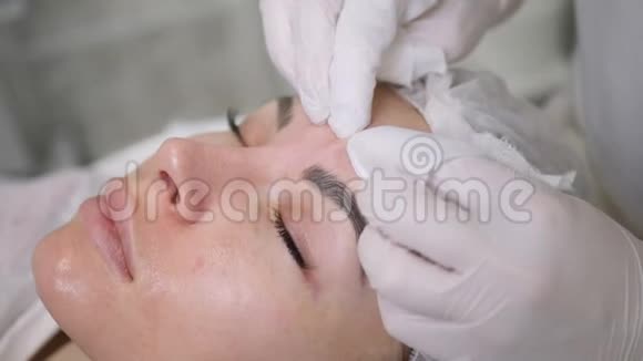 医生的美容师戴着黑色面具为一个年轻女人清洗脸部视频的预览图